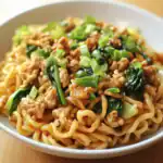 Stir-fried noodles with ground chicken, green onions, and vegetables in a savory Asian-inspired sauce. Perfect for a quick, flavorful meal with wheat noodles and fresh ingredients.