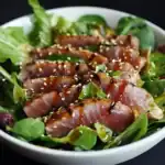 Seared tuna salad with mixed greens, sesame seeds, and a soy-ginger dressing, fresh and flavorful healthy dish.