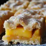 Sweet peach cobbler with a golden crust and fresh peach filling, topped with powdered sugar. Perfect for summer desserts or cozy gatherings, this easy recipe yields juicy, flavorful peach cobbler with a flaky crust.