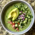Creamy avocado cucumber gazpacho with fresh chopped vegetables and herbs, perfect for a healthy, refreshing appetizer or summer snack. Vegetarian and gluten-free options available.