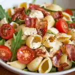 Fresh pasta salad with bacon, cherry tomatoes, greens, and a light dressing, perfect for summer meals and healthy eating. A delicious, flavorful combination of crispy bacon, vine-ripened tomatoes, and tender pasta.