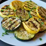 Grilled summer squash and zucchini slices seasoned with herbs and spices, perfect for healthy side dishes or snacks, featuring a delicious blend of smoky flavor and fresh herbs.