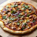 Juicy chicken pizza topped with red onions, cilantro, and melted cheese on a golden crust, perfect for a delicious homemade pizza night.