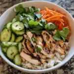 Grilled chicken rice bowl with fresh cucumber, shredded carrots, and cilantro, served over jasmine rice; a healthy, flavorful Asian-inspired meal perfect for lunch or dinner.