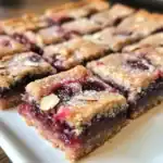 Fresh homemade cherry crumble bars showcasing a layered dessert with cherry filling and crumbly oat topping, perfect for sweet dessert lovers.