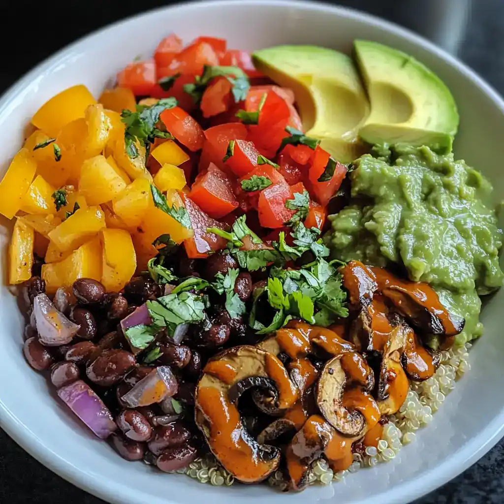 Fresh vegan burrito bowl with black beans, quinoa, avocado, pico de gallo, roasted peppers, and guacamole on a white plate, healthy plant-based meal, colorful and nutritious vegetarian dish.