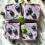 Creamy blueberry cheesecake bars with fresh blueberries and basil garnish, perfect for summer desserts. Simple, delicious, and easy to make at home with fresh ingredients.