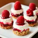 Fresh raspberry cheesecake bites with a graham cracker crust, creamy filling, and raspberry topping, perfect for desserts or special occasions.