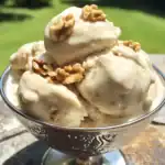 Creamy homemade vanilla ice cream with walnuts in a glass bowl, perfect for summer dessert.