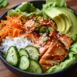 Salmon poke bowl with cucumber avocado carrots and greens, healthy seafood recipe, Asian-inspired dish, fresh salmon salad, nutritious lunch or dinner option.