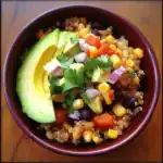 Fresh quinoa salad with avocado, black beans, corn, diced tomatoes, red onion, and cilantro in a wooden bowl. Healthy vegetarian meal perfect for lunch or dinner.