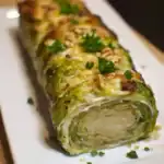 Roasted Brussels sprouts and chicken roulade with herbs and nuts on a white plate, showcasing a healthy and delicious dinner option for meal prep.
