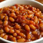Baked beans in tomato sauce close-up, delicious seasoned baked beans, classic comfort food, hearty and flavorful baked beans recipe, station recipes.