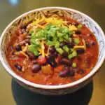 1. Hearty vegetarian black bean chili in a decorative bowl, topped with chopped green onions and shredded cheese, perfect for healthy, easy dinner recipes.