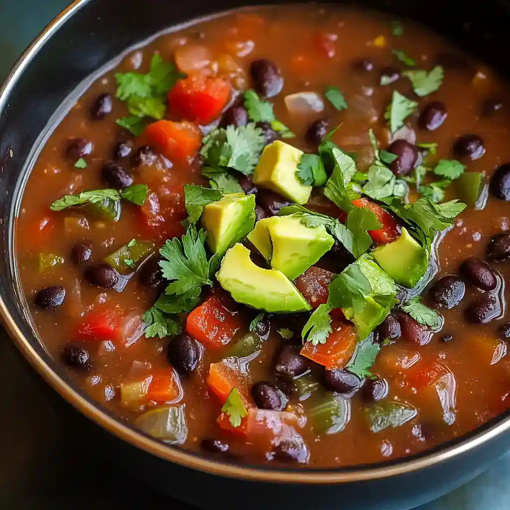 Creamy Black Bean and Vegetable Chili with Avocado Garnish - Easy, flavorful recipe for a hearty plant-based meal. Perfect for lunch or dinner, packed with protein and fresh herbs.