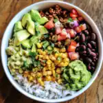 Fresh vegan rice bowl with avocado, black beans, corn, salsa, and seasoned plant-based protein for healthy meal ideas. Perfect for plant-based diet and quick lunch recipes.