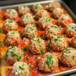 Juicy meatballs baked in marinara sauce, topped with grated cheese and fresh parsley, perfect for Italian-inspired dishes or cozy dinner options.