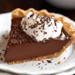 Rich chocolate pie with whipped cream and chocolate shavings on top, served on a white plate. Perfect for dessert lovers and easy to make for special occasions or everyday treats.
