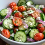 Fresh cucumber cherry tomato salad with feta cheese, red onion, and herbs - healthy, easy-to-make vegetarian side dish or appetizer.
