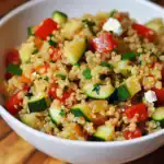 Light and fresh quinoa salad with chopped cucumber, cherry tomatoes, parsley, and feta cheese, perfect for healthy meal prep or summer picnics.
