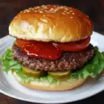 Juicy beef burger with fresh lettuce, tomatoes, pickles, and ketchup on a toasted sesame bun. Perfect for a classic American meal.