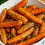Sweet glazed carrots with herbs and black pepper, perfect side dish for any meal.