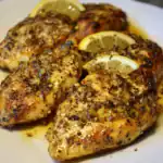 Grilled chicken thighs with lemon and herb seasoning, topped with black pepper and olive oil, served with fresh lemon wedges for added flavor. Perfect for dinner or meal prepping.