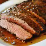 Juicy and tender grilled steak with a flavorful garlic and herb marinade, cooked to perfection, served with a savory sauce. Ideal for steak lovers and dinner recipes.