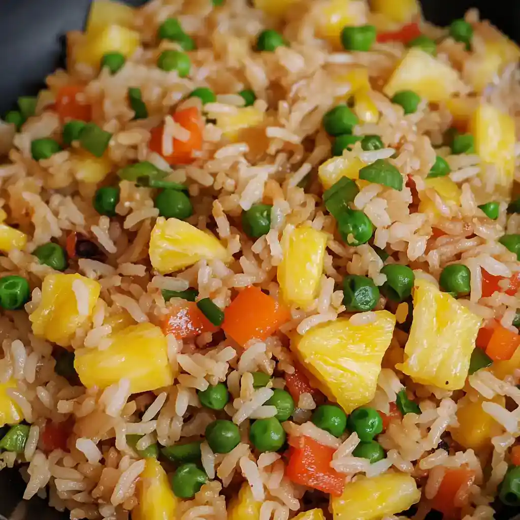 Crispy pineapple fried rice with mixed vegetables, green peas, and colorful bell peppers served in a skillet. Perfect for quick, delicious Asian-inspired meals.