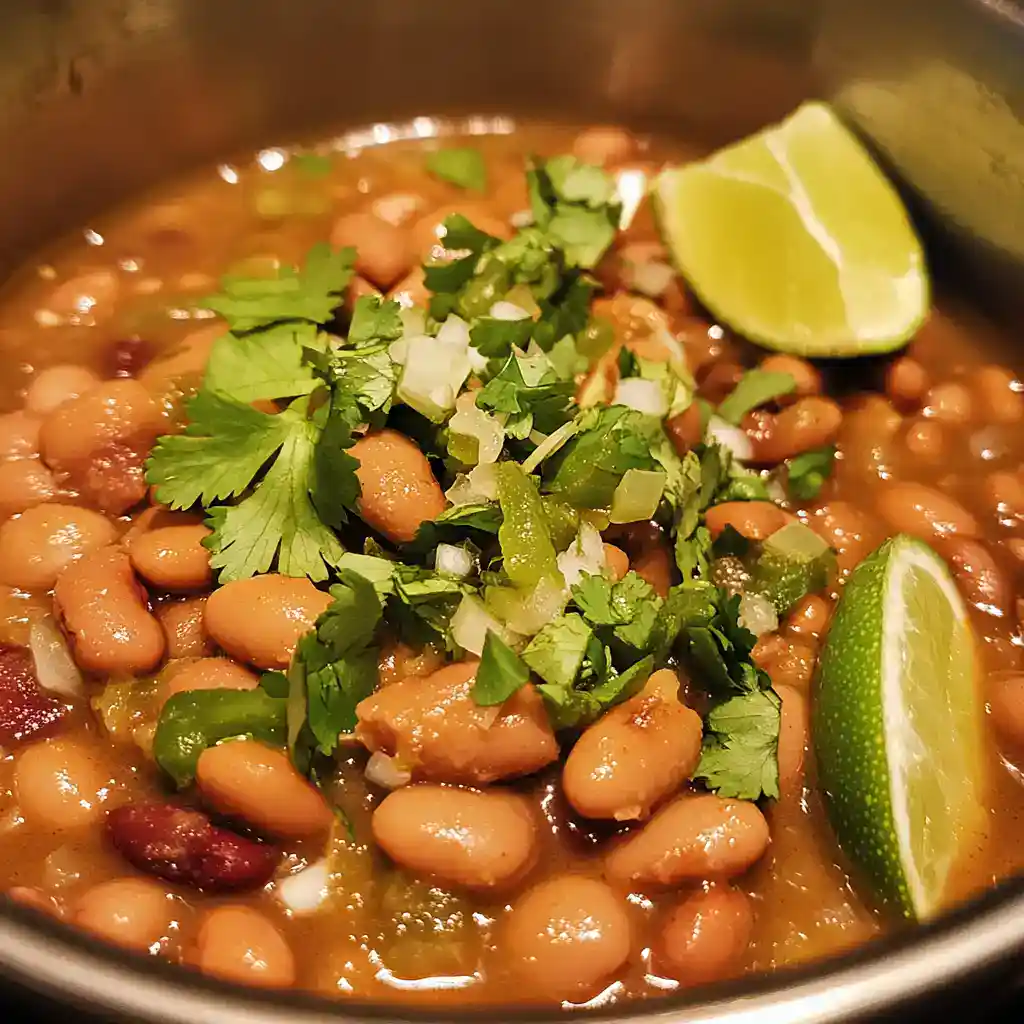 Delicious bean chili garnished with fresh cilantro, chopped onions, and lime wedges, perfect for a hearty and flavorful meal or cozy gathering.