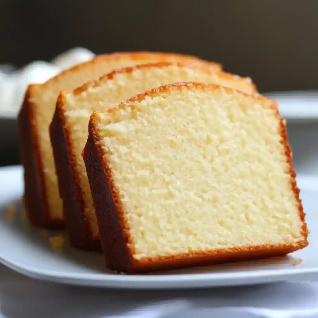 Fluffy vanilla sponge cake slices on a white plate, perfect for dessert or tea time.