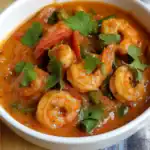 Succulent shrimp curry with vibrant vegetables and fresh cilantro, served in a flavorful spicy sauce, perfect for enjoying authentic Indian and Thai cuisine.