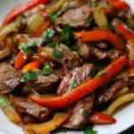 Beef stir-fry with colorful bell peppers and fresh herbs, a quick and healthy meal recipe from Station Recipes.