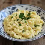 Creamy scrambled eggs garnished with fresh parsley served in a decorative bowl for breakfast.
