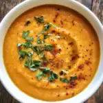 Creamy butternut squash soup garnished with fresh herbs and spices, perfect for cozy fall recipes and healthy meal ideas. Ideal for homemade soup lovers.