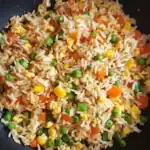 Stir-fried rice with mixed vegetables, scrambled eggs, and savory seasonings, perfect for quick, healthy meals or Chinese-inspired recipes.