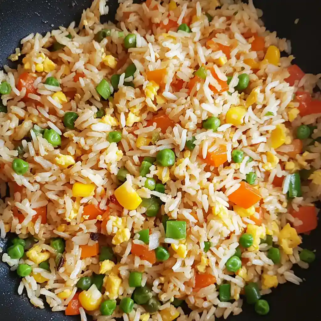 Stir-fried rice with mixed vegetables, scrambled eggs, and savory seasonings, perfect for quick, healthy meals or Chinese-inspired recipes.