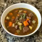 Comforting beef stew with tender beef, carrots, celery, and potatoes in a savory broth. Perfect for cold days and easy to make with simple ingredients.