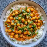 Delicious chickpea curry served over fluffy white rice, garnished with fresh cilantro. Perfect for a flavorful, vegetarian meal that's easy to prepare and packed with protein.
