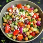 Bright, fresh chickpea salad with tomatoes, cucumbers, red onions, olives, feta cheese, and herbs, perfect for healthy meals and quick snacks.