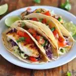 Delicious grilled fish tacos filled with fresh vegetables, cilantro, and served with lime wedges for a flavorful Mexican meal option. Perfect for a quick lunch or dinner.