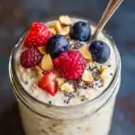 Fresh berries and nuts on creamy oats for healthy breakfast.