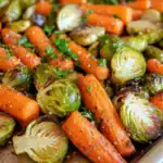 Freshly roasted carrots, Brussels sprouts, and garlic with herbs, perfect for healthy eating and meal prep.