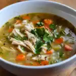 Delicious homemade chicken soup with vegetables, herbs, and tender chicken in a flavorful broth, perfect for comfort and wellness.