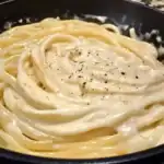 Delicious homemade Alfredo pasta dish topped with freshly ground black pepper, perfect for quick, comforting meals. Easy recipe for a creamy, cheesy Italian-inspired dinner.