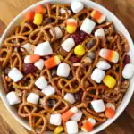 Delicious Halloween snack mix featuring pretzels, mini marshmallows, chocolate chips, dried cranberries, and candy corn, perfect for Halloween parties and celebrations.