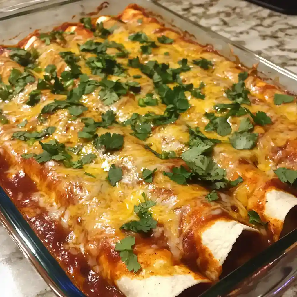 Delicious baked enchiladas filled with chicken, cheese, and topped with fresh cilantro, perfect for family dinners or casual gatherings. A flavorful, easy-to-make Mexican-inspired dish.