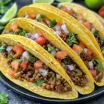 Delicious beef tacos with fresh chopped tomatoes, onions, cilantro, and seasoned ground beef in crispy taco shells. Perfect for quick, authentic Mexican dinner or snack.