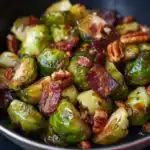 Delicious roasted Brussels sprouts topped with crispy bacon and toasted pecans, perfect for a healthy side dish or appetizer. Easy to prepare and full of flavor.