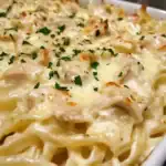 Delicious homemade chicken Alfredo featuring tender chicken, creamy sauce, and perfectly cooked pasta, garnished with fresh parsley for an irresistible comfort food experience.